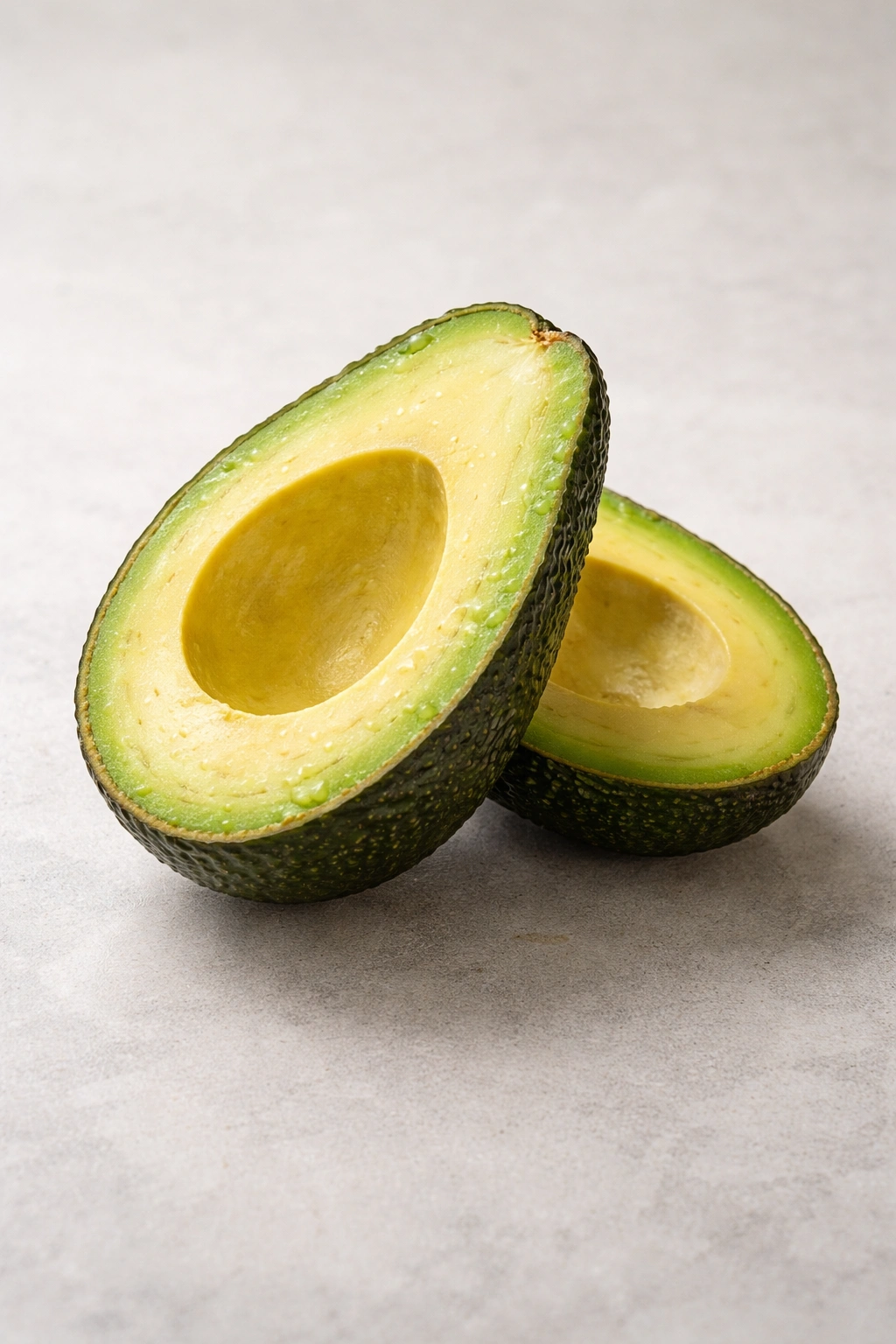 Halved avocado on plain background suggesting caution for digestion