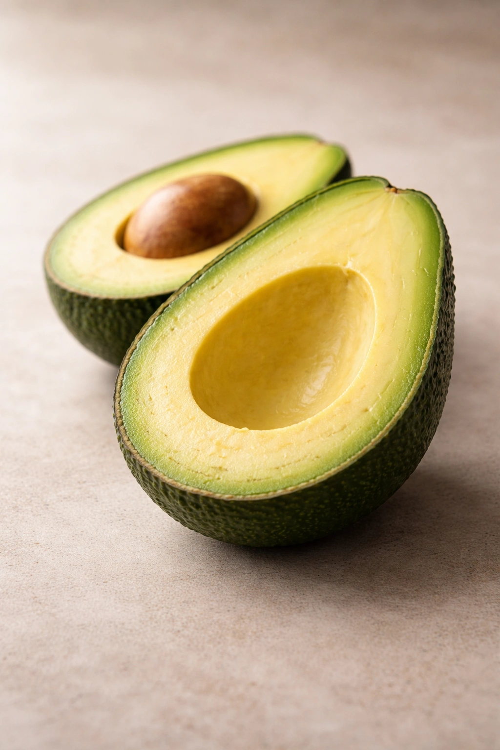 Halved avocado showing creamy green flesh on neutral background, highlighting digestion-friendly fiber and potassium