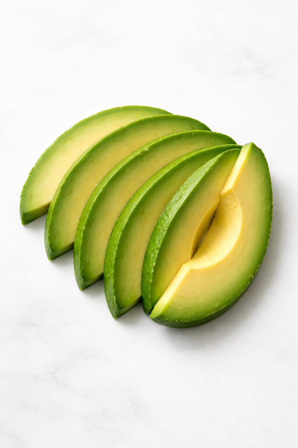 Sliced avocado arranged on a plain surface illustrating safe dietary inclusion
