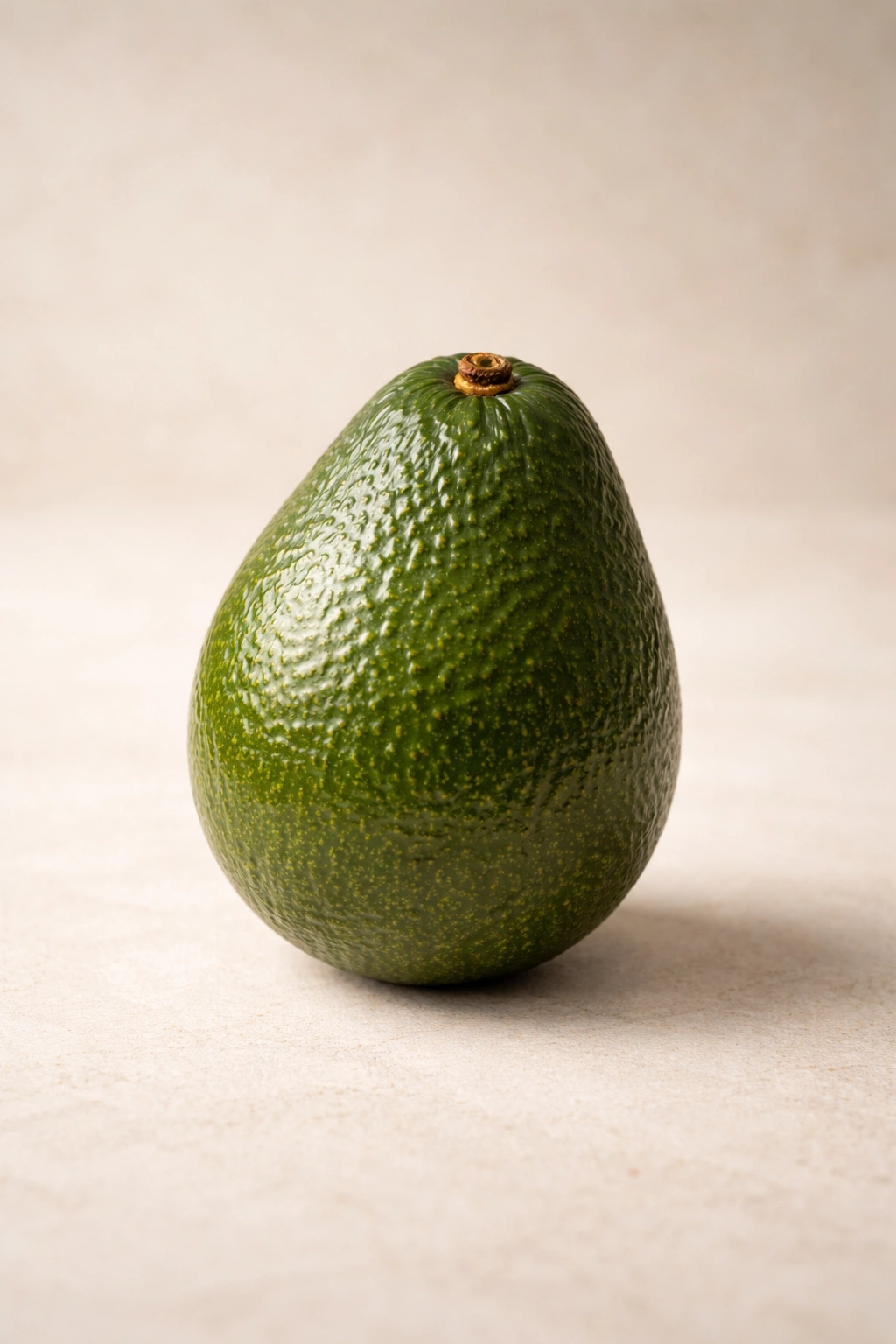 Single avocado on neutral background representing summary of avocado benefits for diarrhea