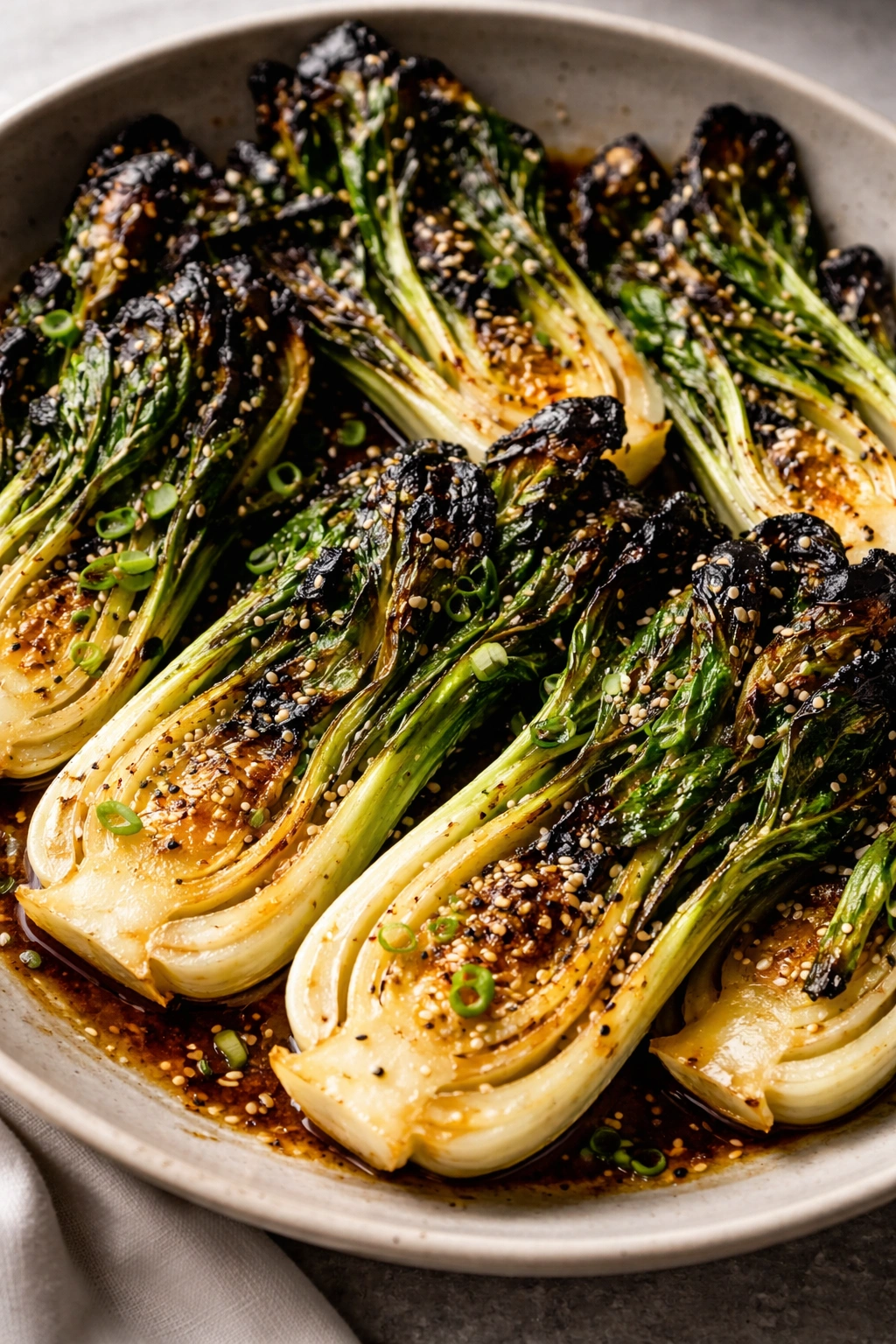 Close-up of charred bok choy halves with sesame seeds