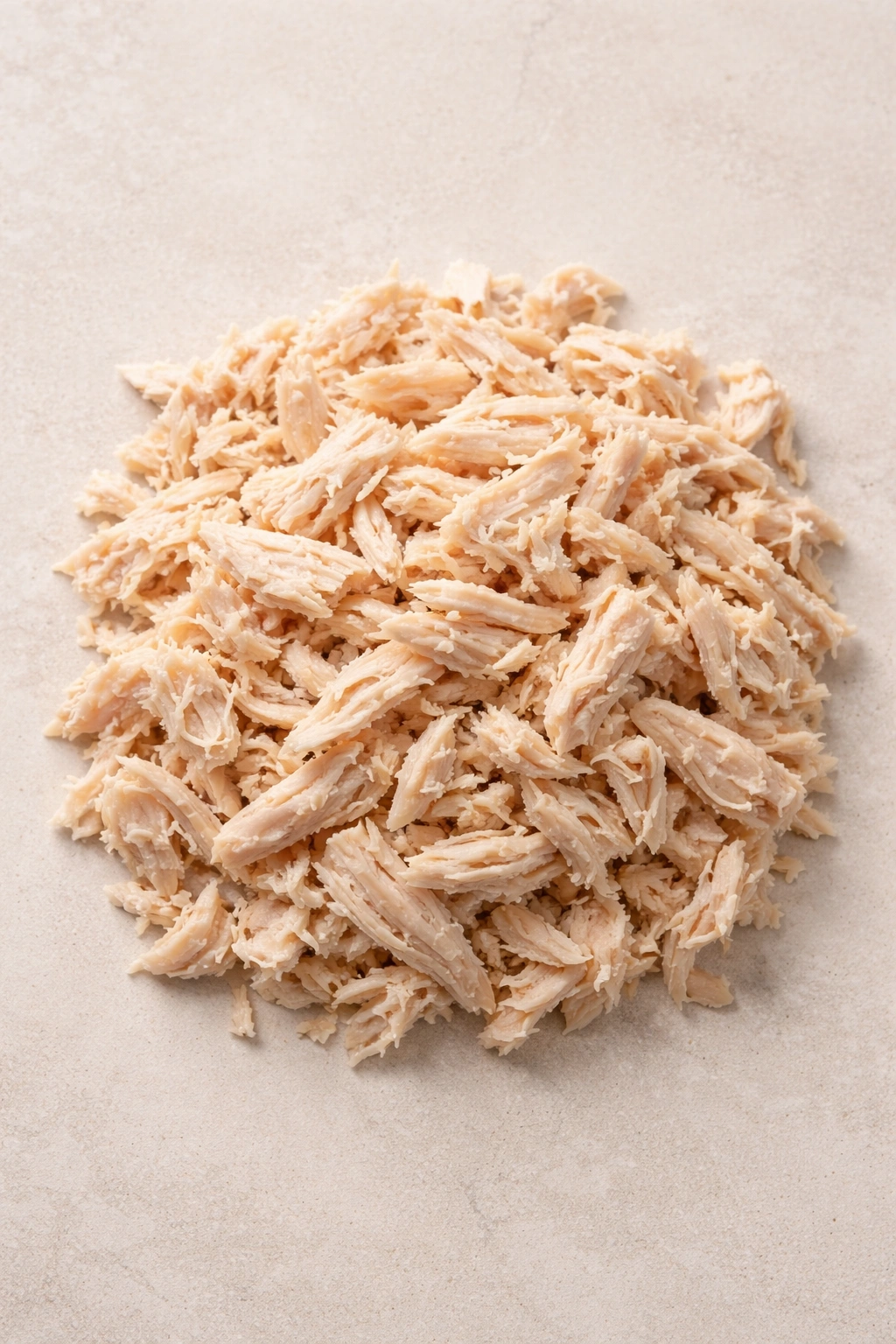 Shredded canned chicken mound on neutral surface