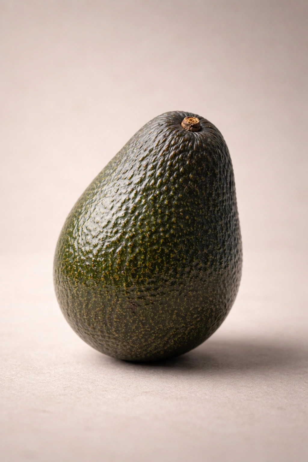 Single avocado on plain backdrop showing mature skin texture