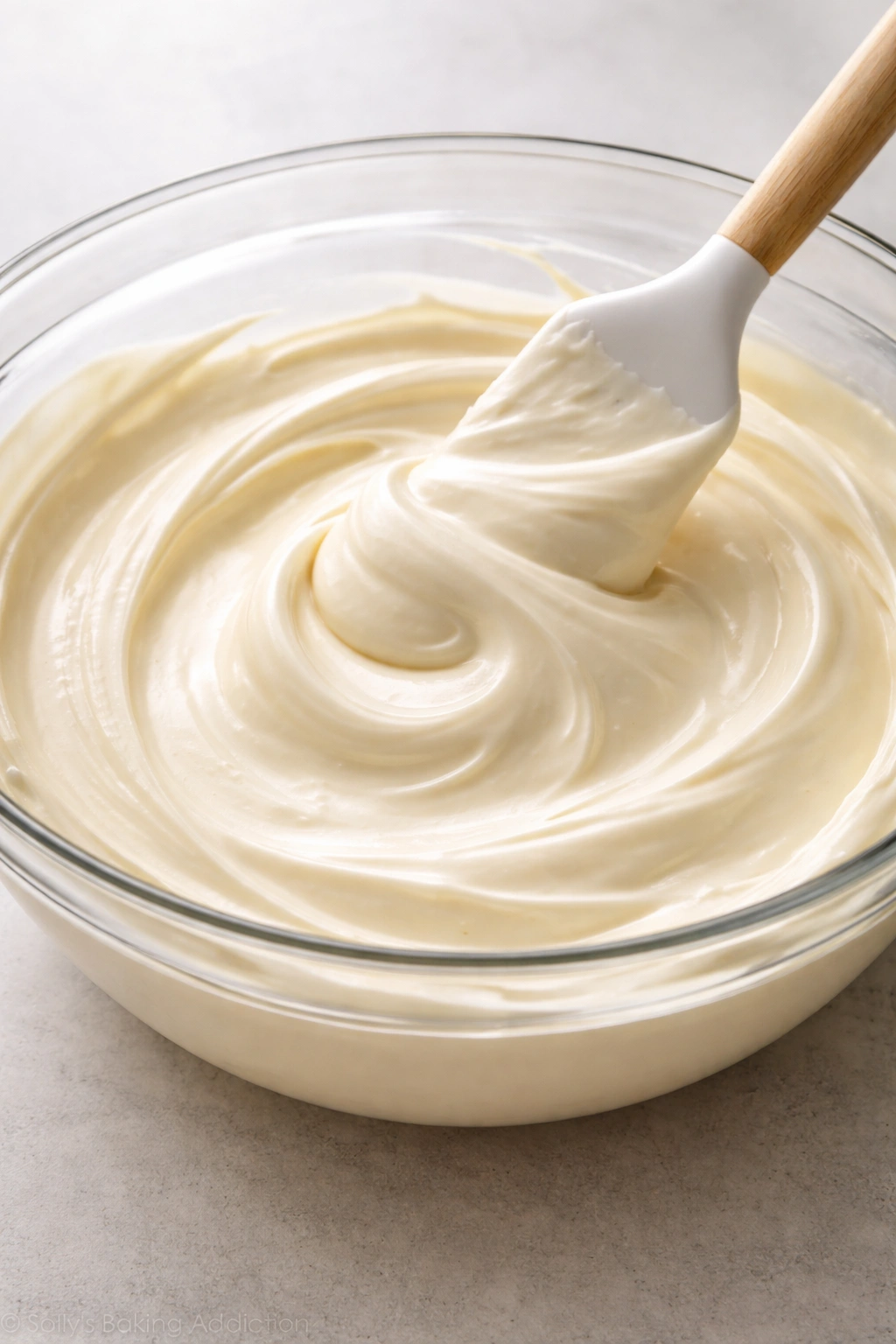 Glossy pale cheesecake filling in a glass bowl