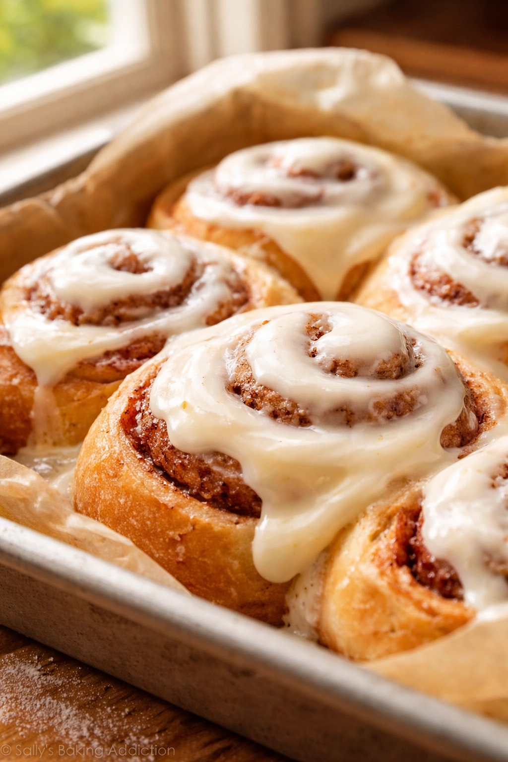 Cinnamon rolls with silky cream cheese frosting soaking into swirls