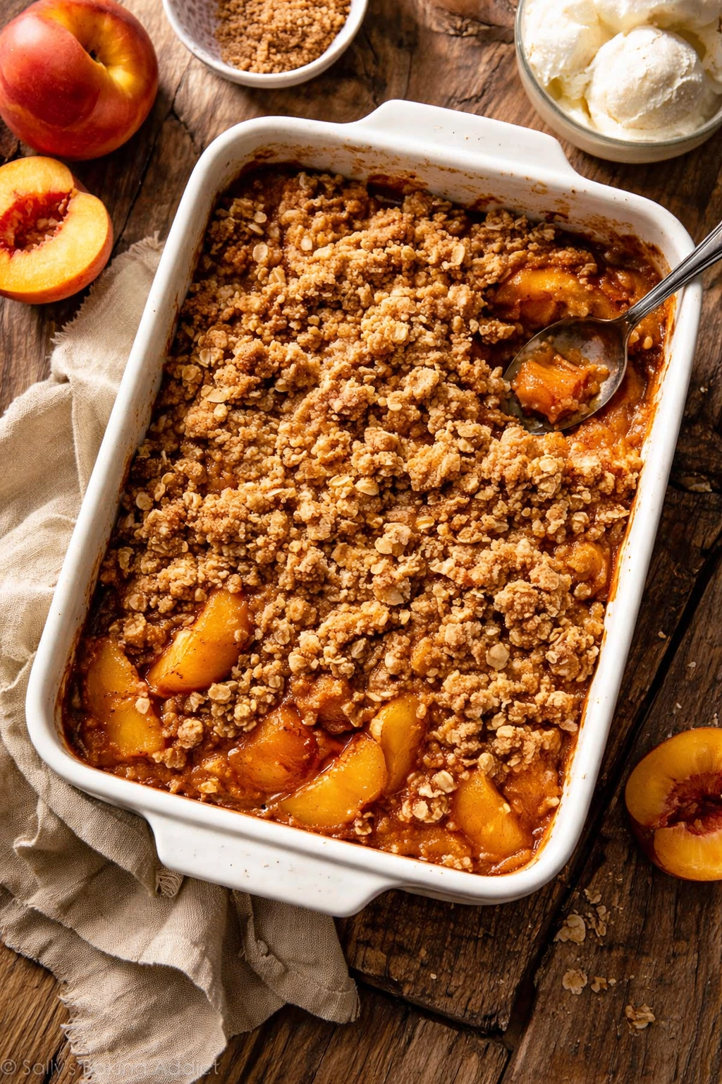 Warm peach crisp cooling on a rustic wood table