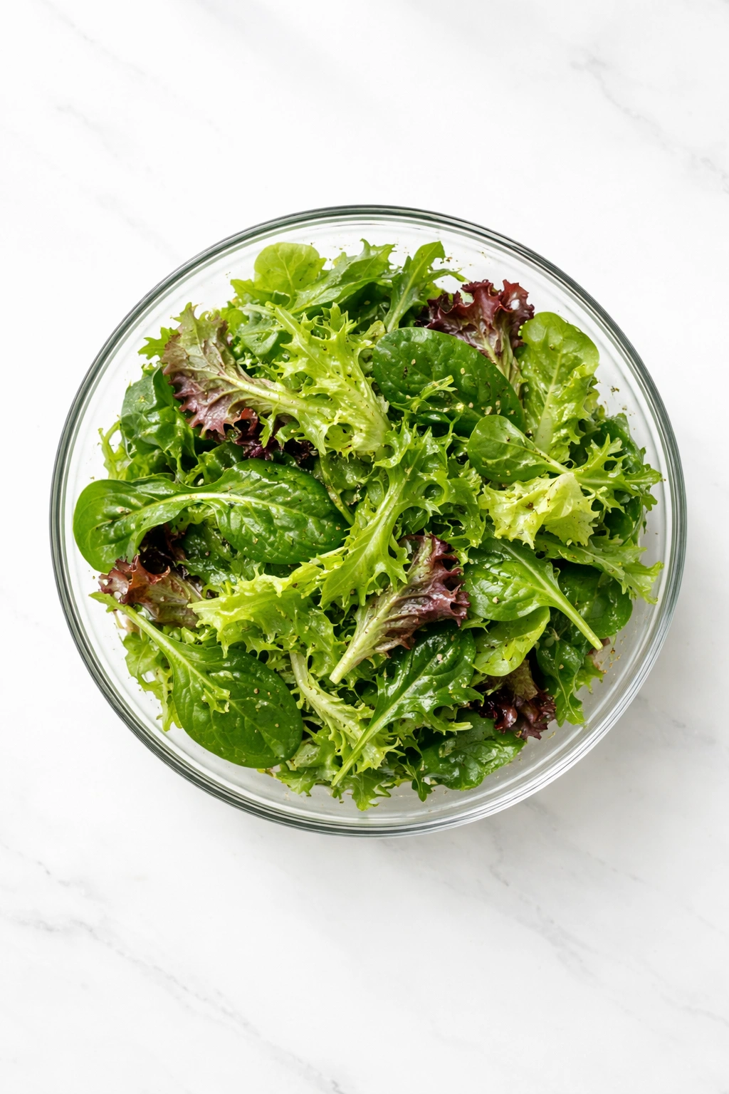 Top-down view of simple green salad with light vinaigrette
