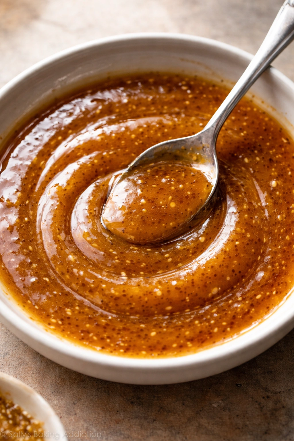 Glossy honey mustard glaze in a shallow dish, warm amber color.