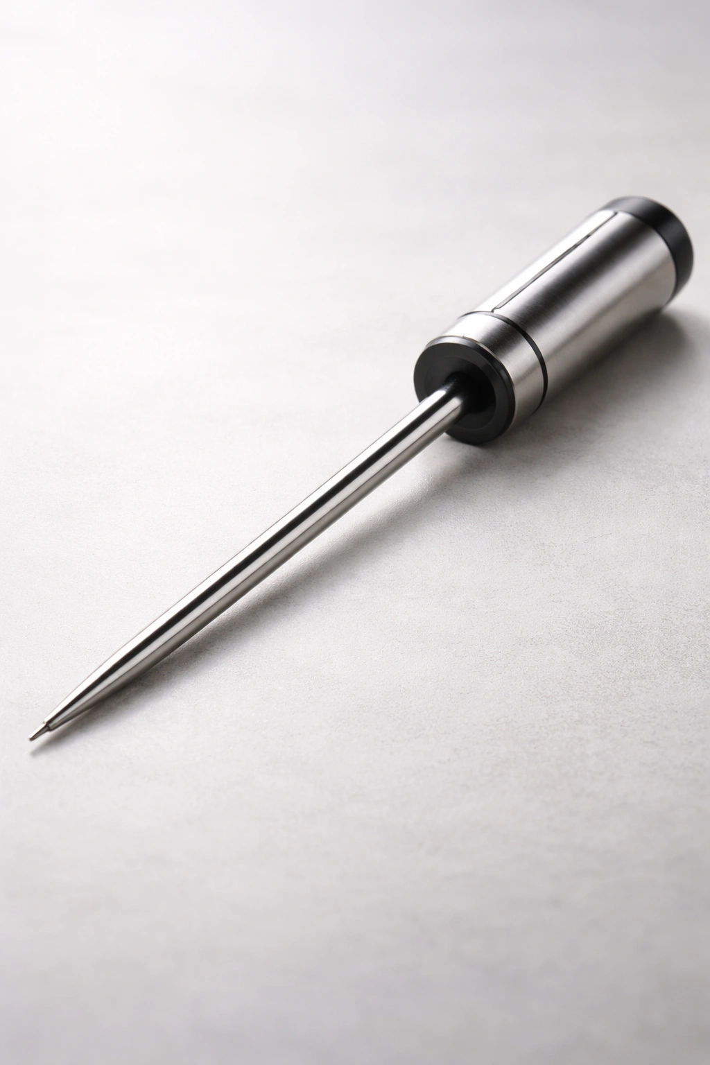 Meat thermometer with long probe on a plain background