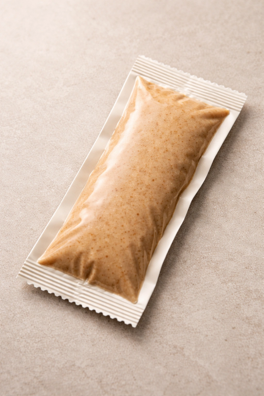 Unbranded nut butter packet on neutral background