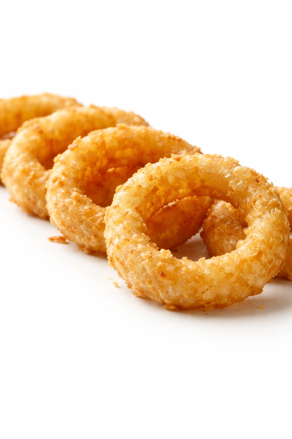 Close-up of crispy onion rings with light batter on white background