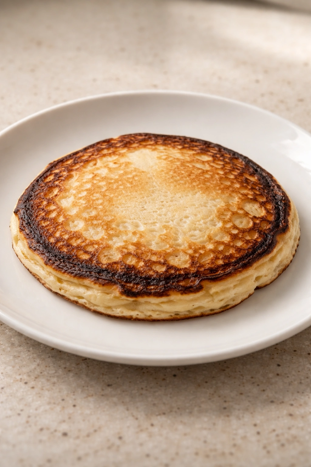 Close-up of a pancake with burnt edges and pale center illustrating common mistakes
