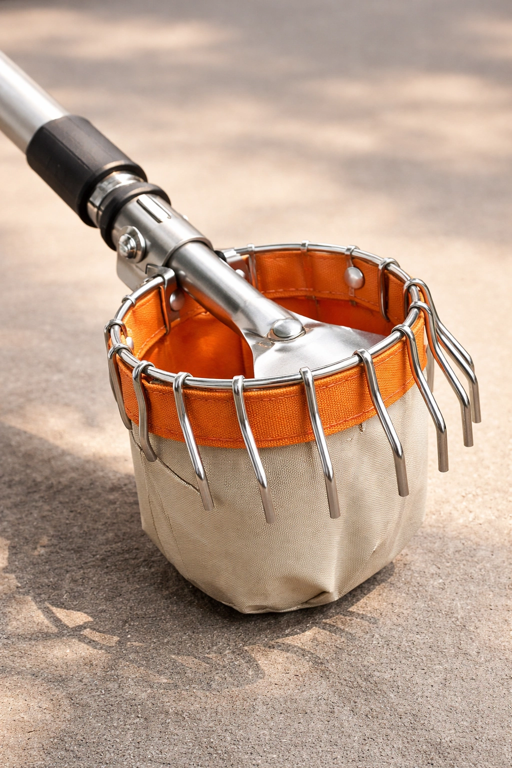 Close-up of premium fruit picker components showing aluminum handle and stainless steel tines