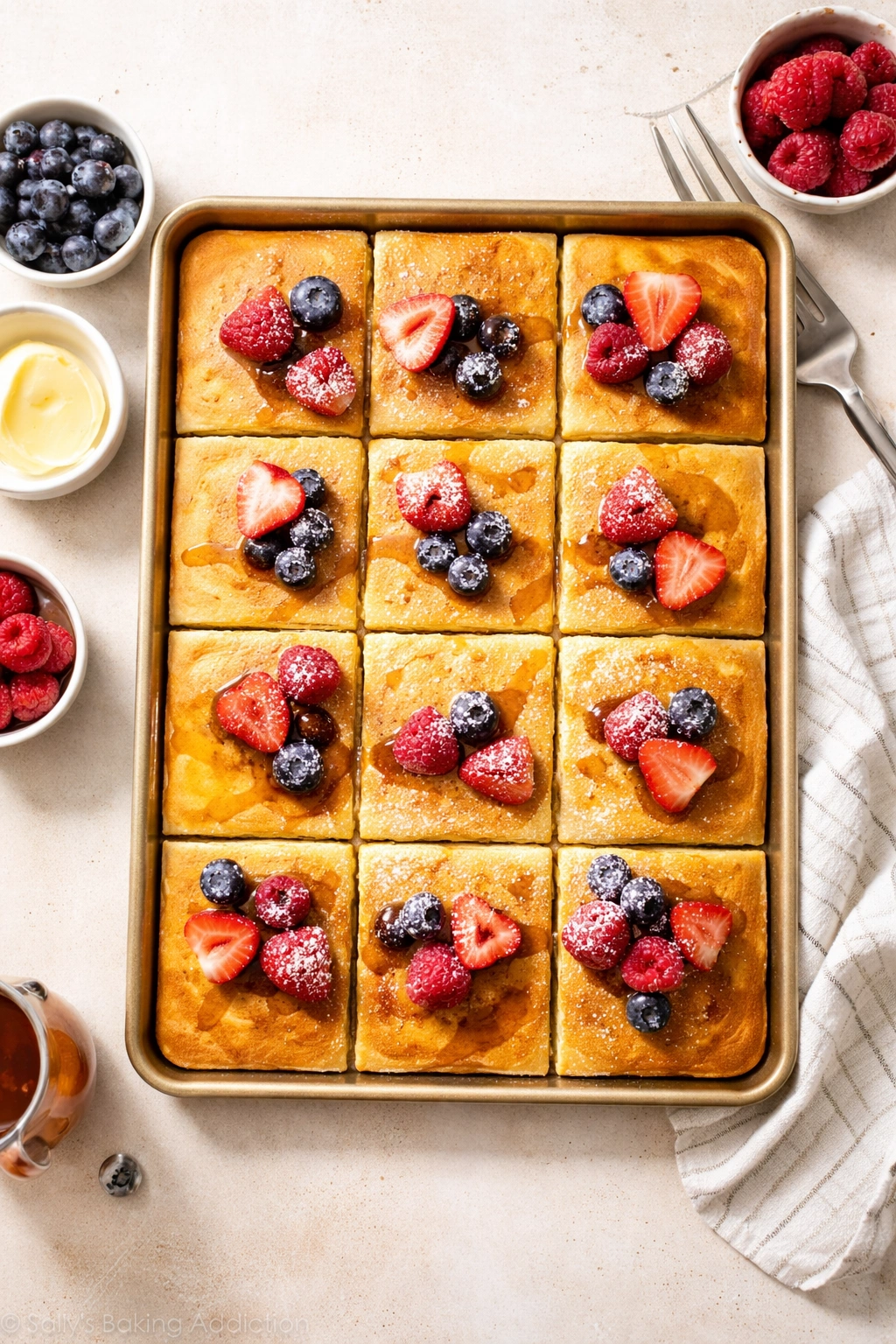 Overhead view of sheet pan pancakes arranged in a grid on a light counter