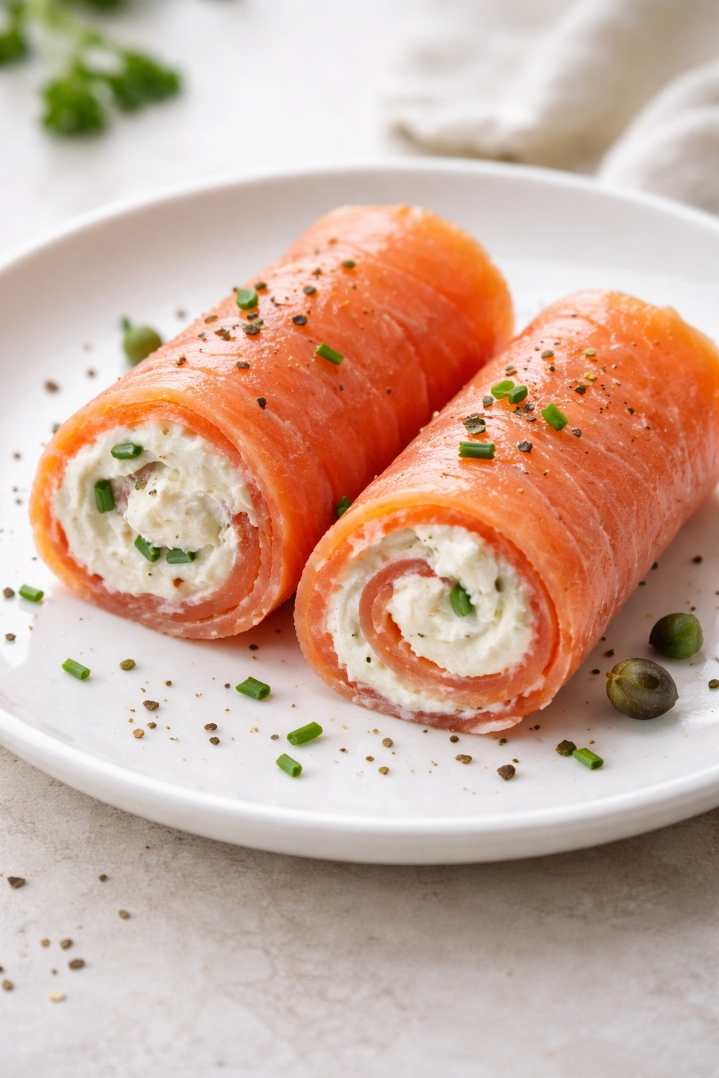 Smoked salmon and cream cheese roll-ups on a plate