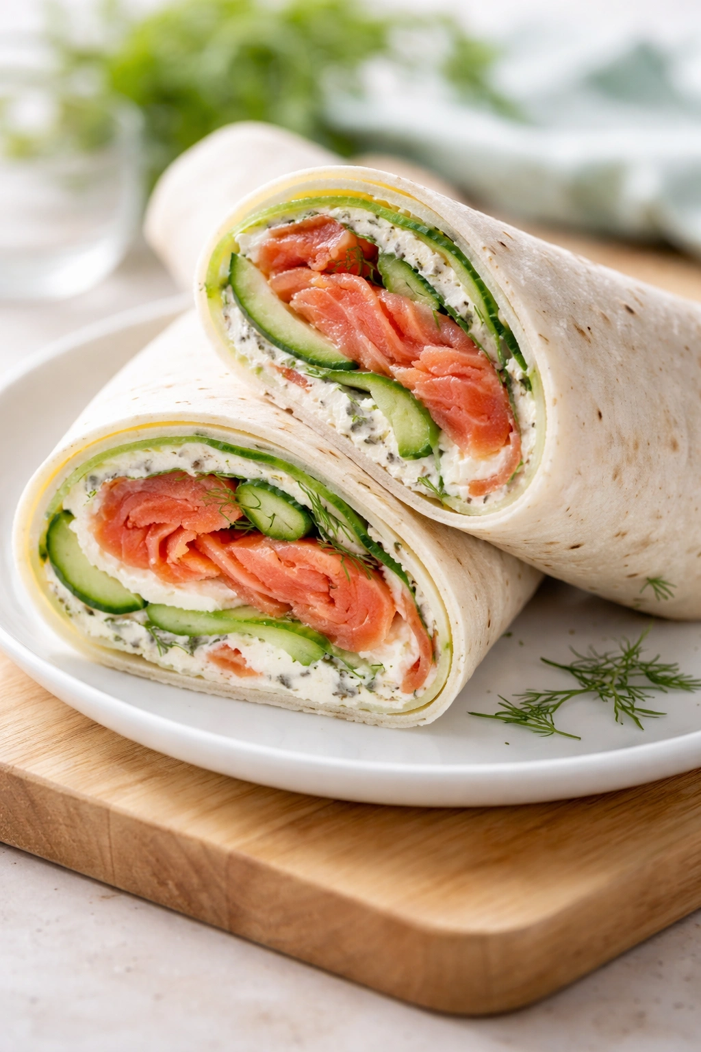 Cross-section of smoked salmon and cream cheese wrap showing salmon, cream cheese, dill, cucumber