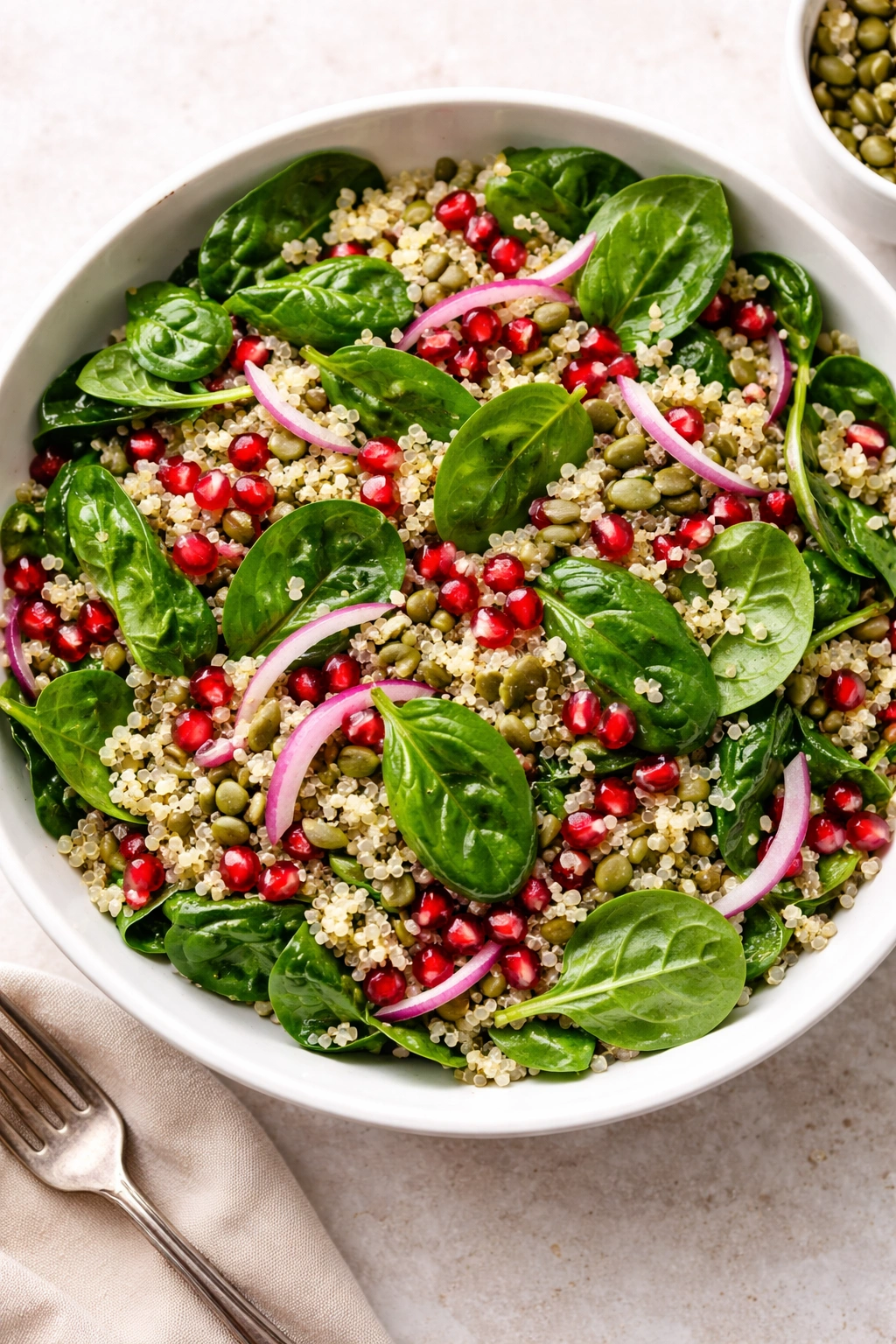 Spinach quinoa pomegranate salad with pumpkin seeds and red onion