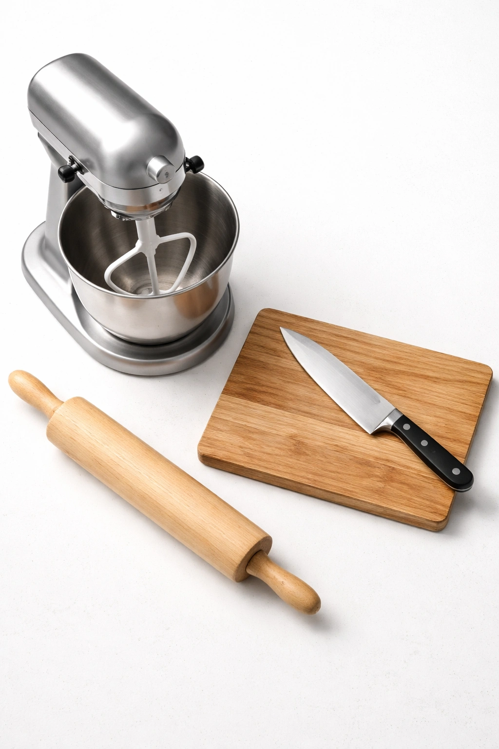 Stand mixer, rolling pin, knife, and cutting board arranged neatly