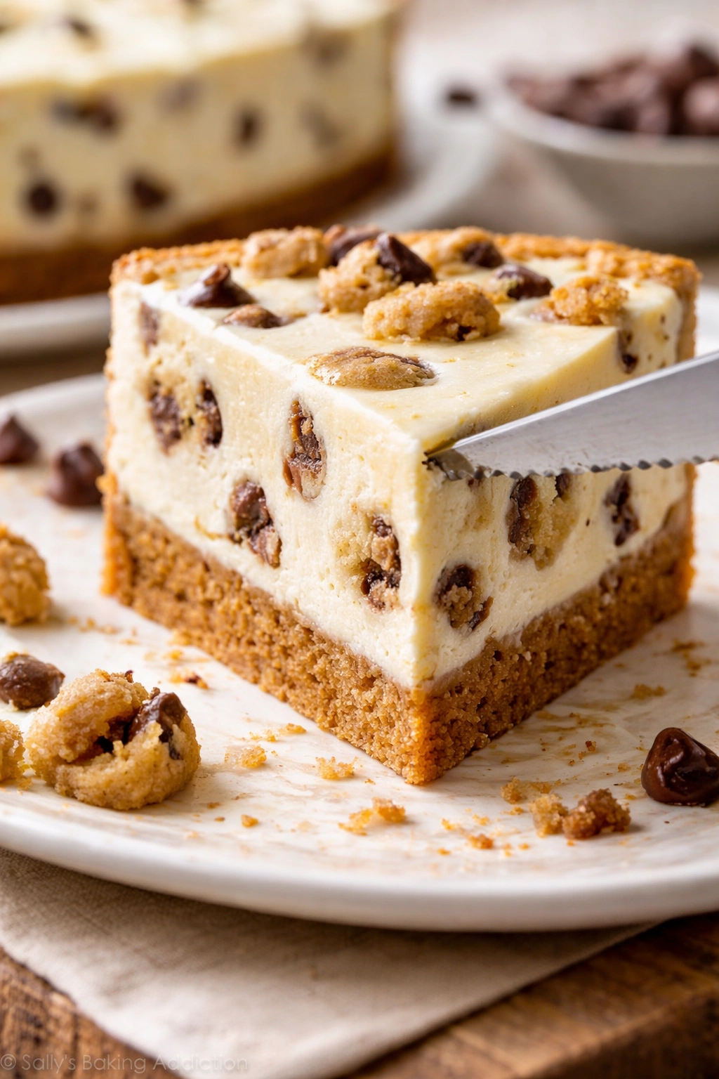 Close-up of cheesecake slice with a serrated knife preparing to cut.