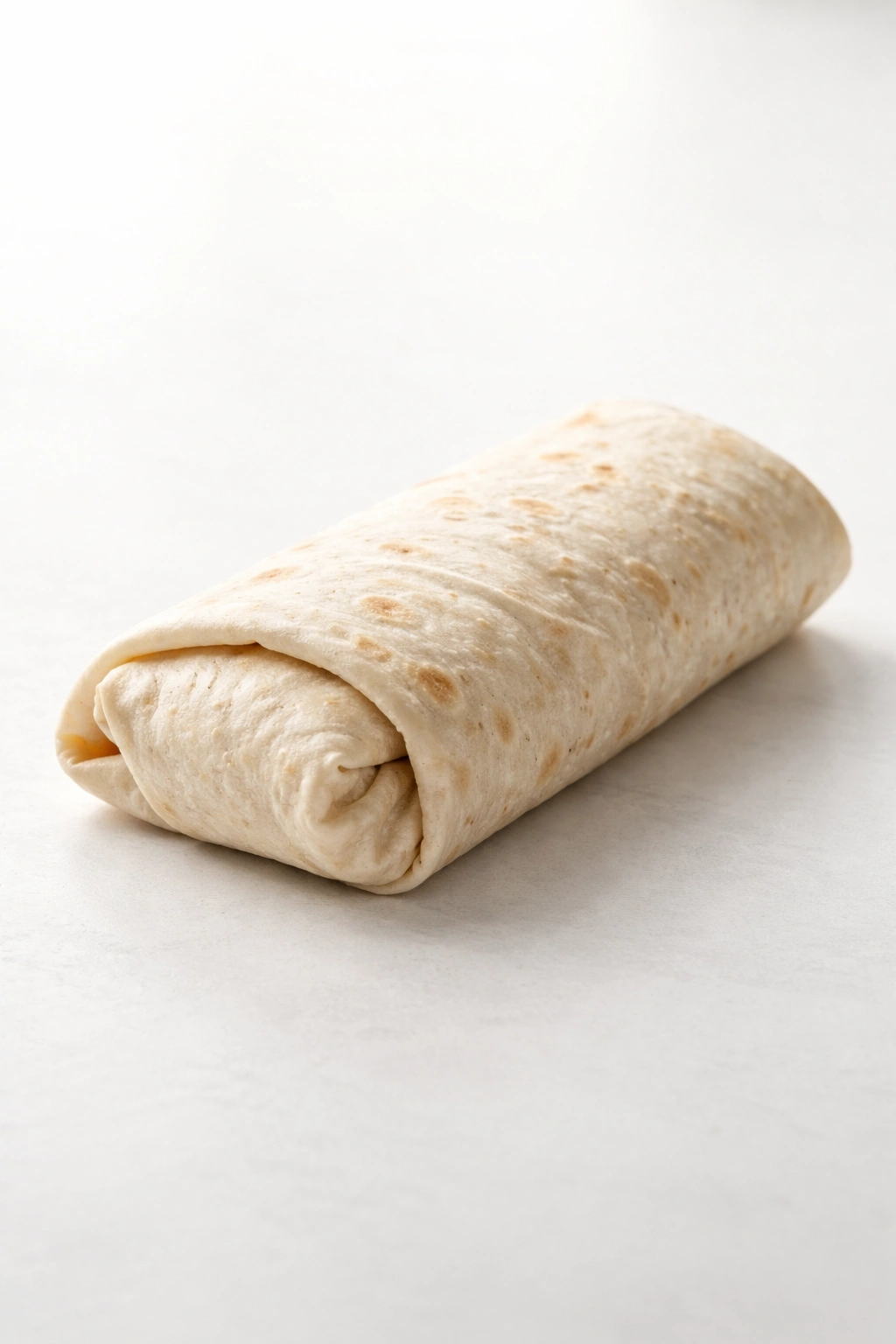 Close-up of a neatly wrapped burrito on a plain surface symbolizing wrapping up a meal