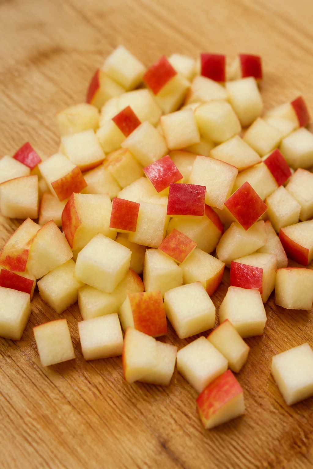 Small diced apple pieces on a light wooden surface