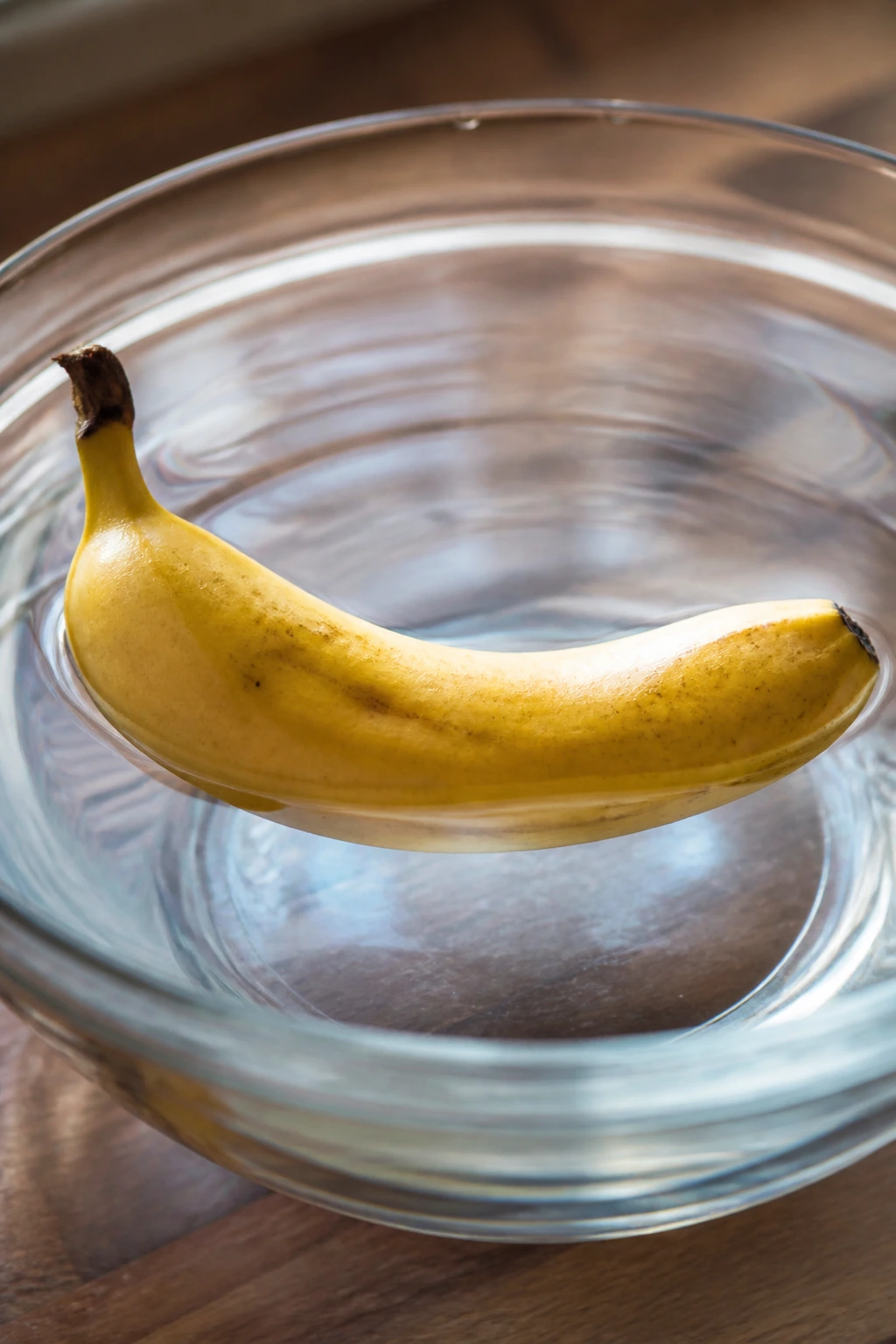 Do Bananas Float In Water? Yes And Here's Why 1 Close-up of a banana floating in clear water, highlighting buoyancy and water interaction.