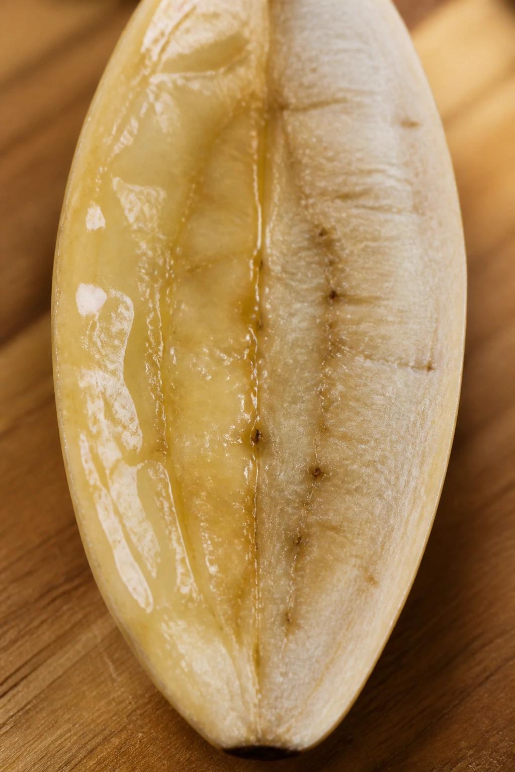 Close-up of a ripe banana half with partial glaze, suggesting mixed preservation methods on a warm kitchen counter.