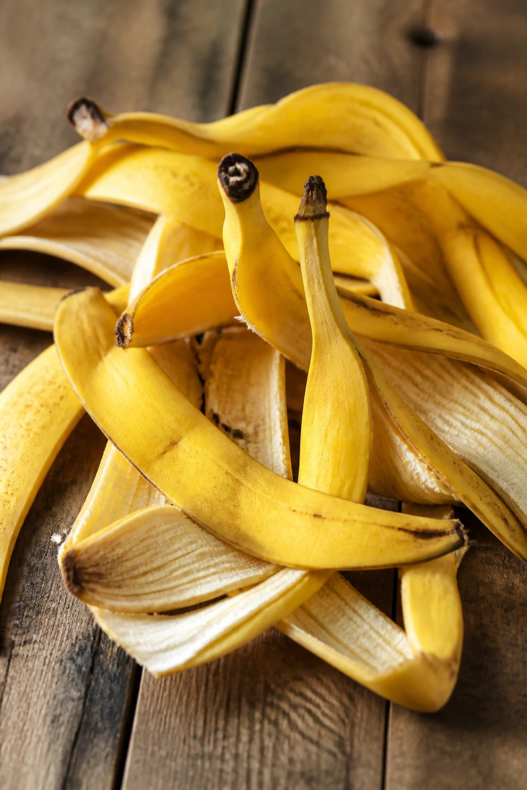Banishing Breakouts: Are Banana Peels Good For Acne? 9 Close-up of stacked banana peels filling the frame on a wooden table