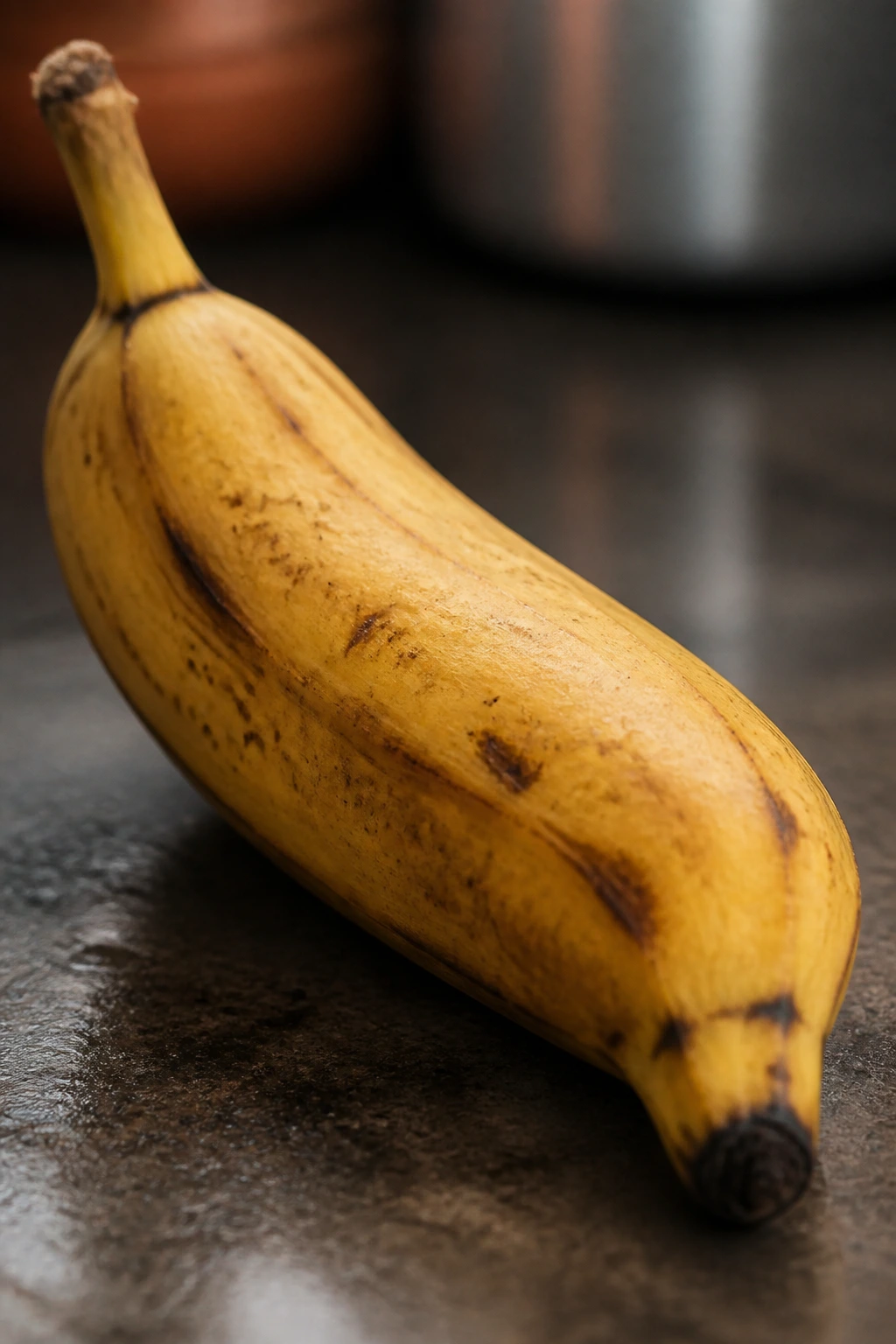 Can Guinea Pigs Eat Bananas And Banana Peel? 5 Close-up of a banana with brown spots on a dim kitchen surface