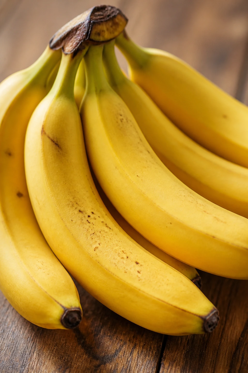 Are Bananas Good For Eczema? 2 Close-up of ripe bananas on a wooden counter in warm light