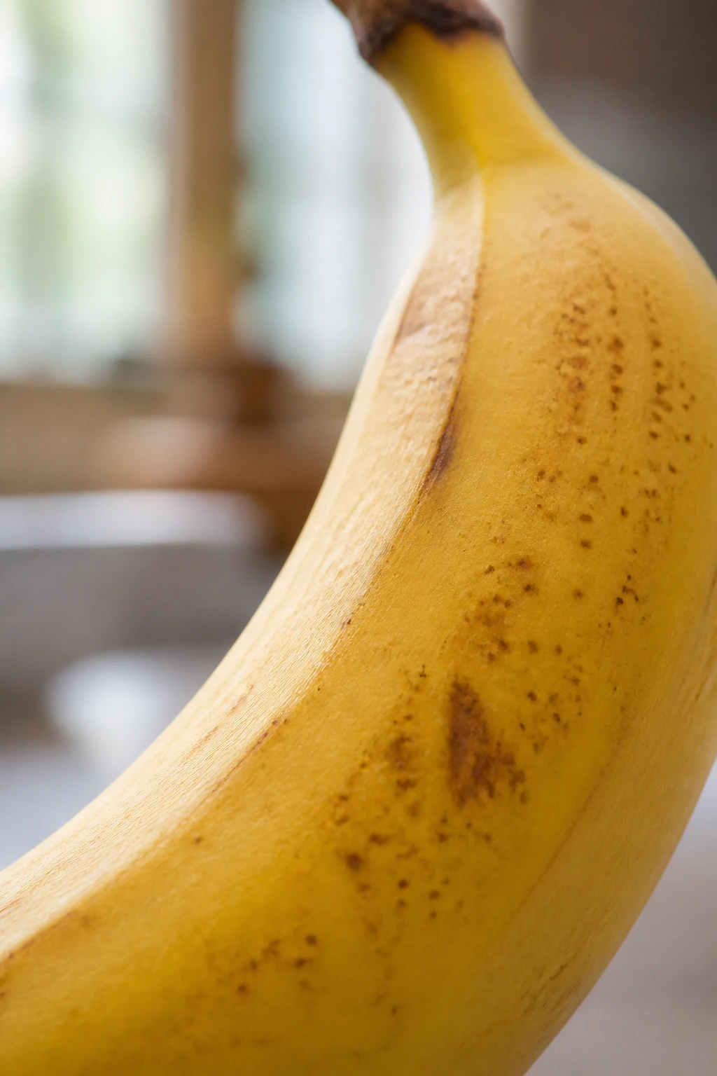 Close-up of a ripe banana with soft kitchen light