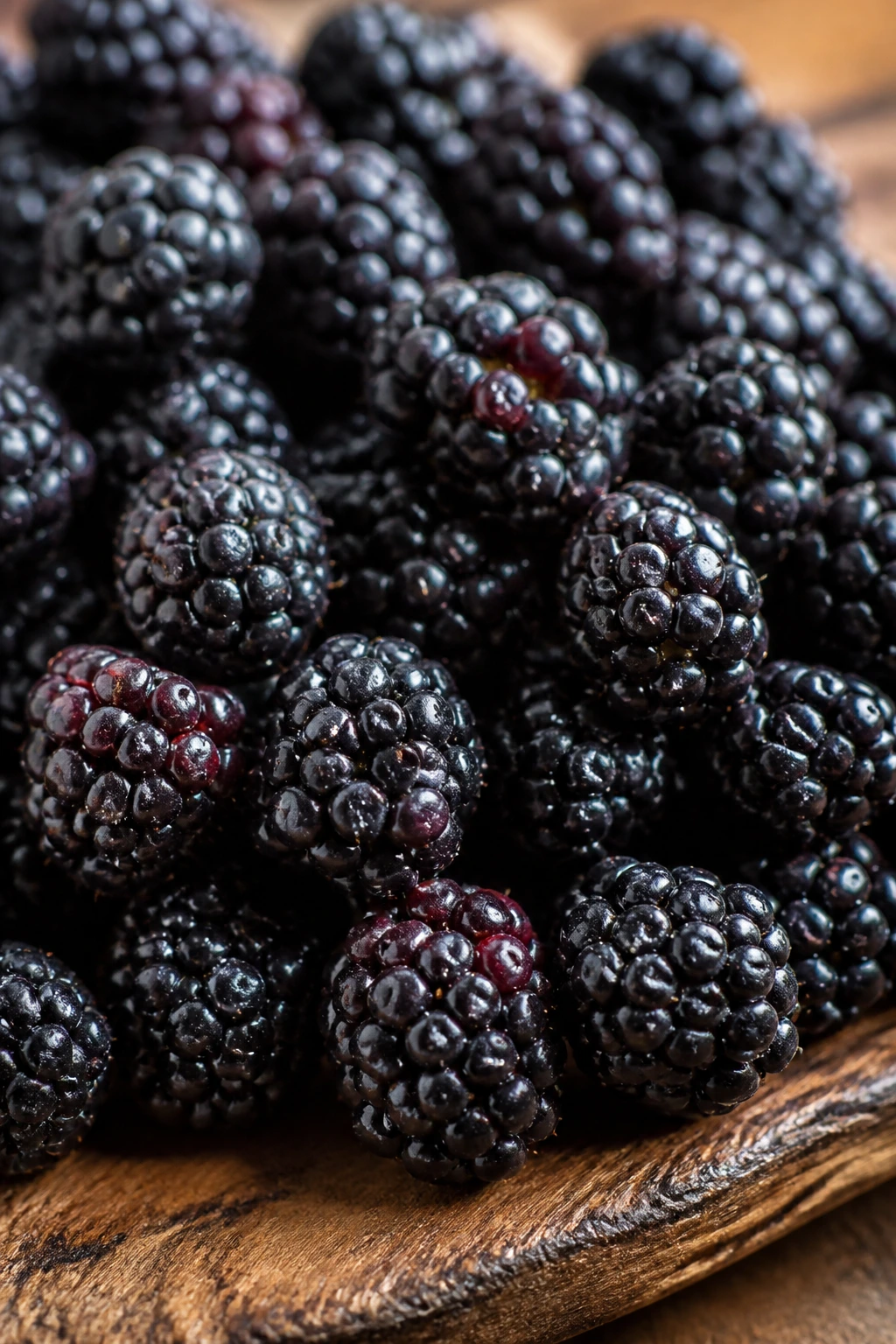 Are Blackberries Good For Your Skin? All You Need To Know 1 Close-up of ripe blackberries on a wooden cutting board