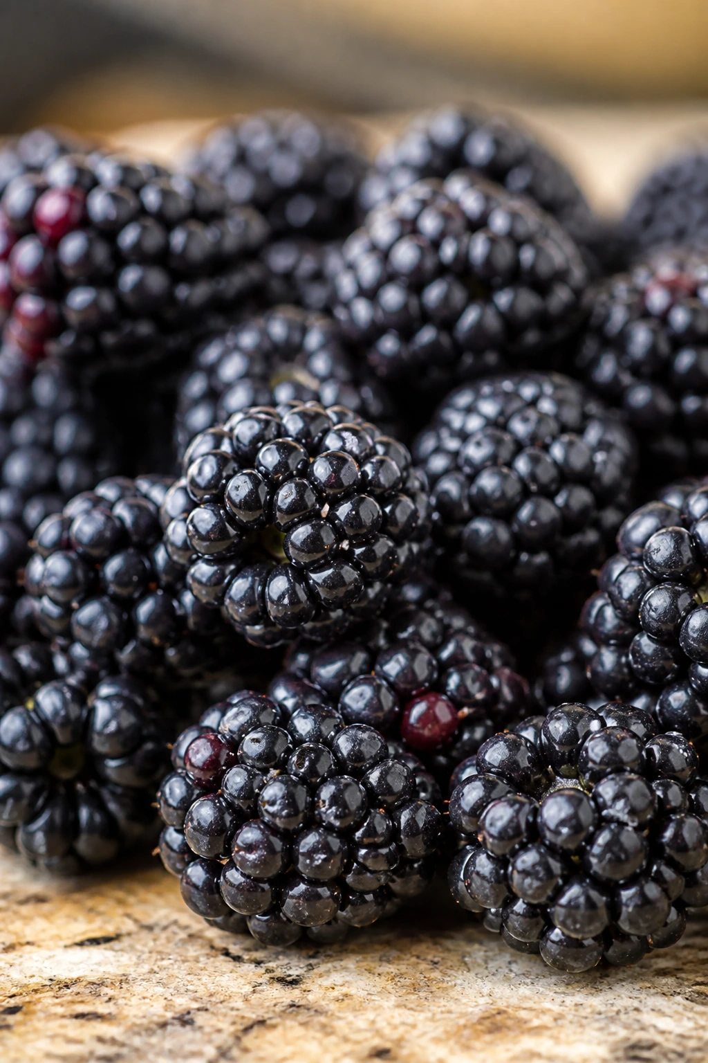 How Long Do Blackberries Last In The Fridge? 4 Close-up of fresh blackberries on a kitchen counter under natural light.