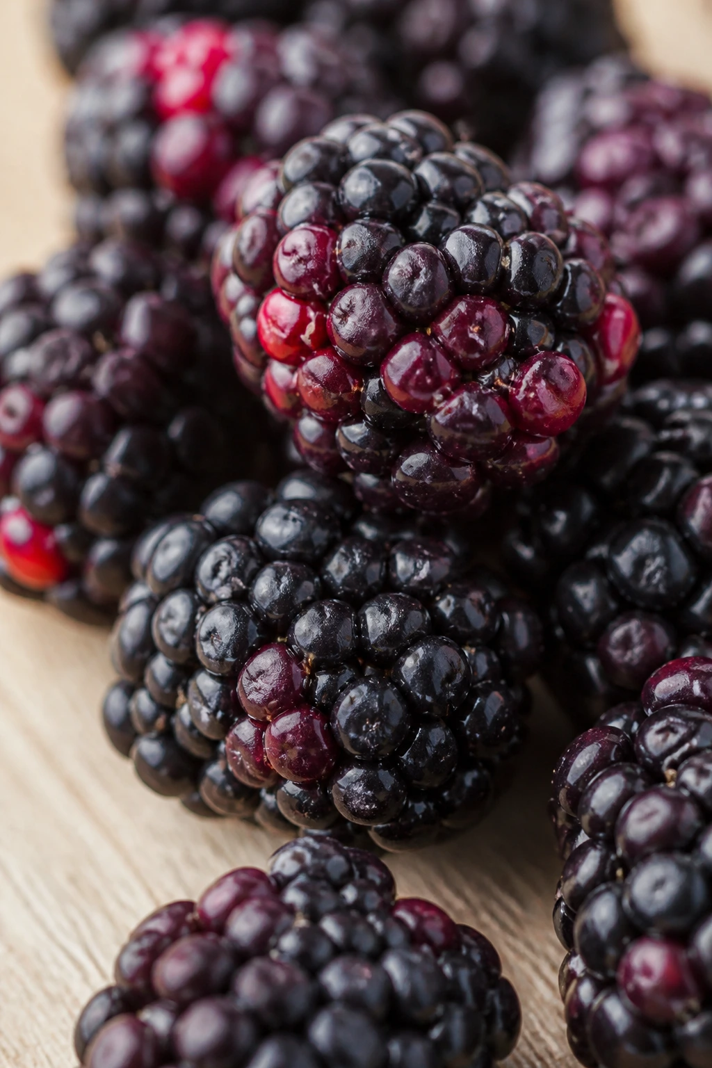 Are Boysenberries Good For You? All You Need To Know 2 Several ripe boysenberries on a wooden counter with warm light