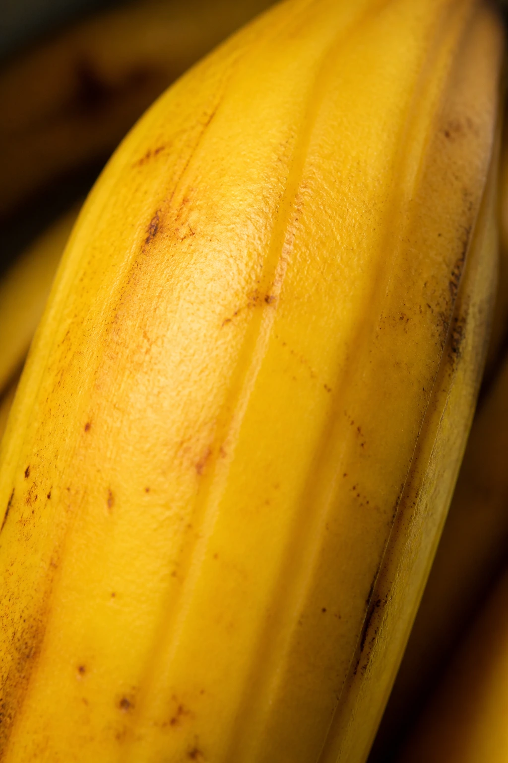 Why Are Bananas Yellow? How Do They Get Their Yellow Color? 3 Macro banana peel with yellow-orange carotenoid tones