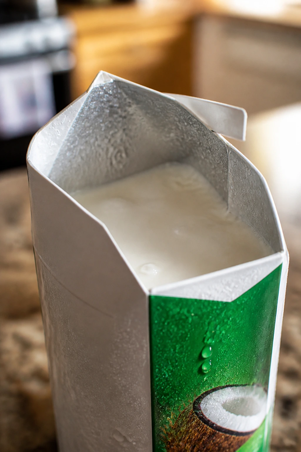 What Does Bad Coconut Milk Taste Like? 2 Opened coconut milk carton with condensation in a kitchen