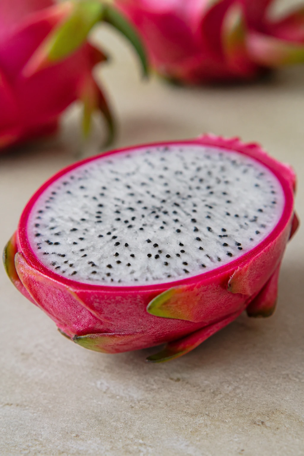 10 Dragon Fruit Benefits for Thyroid Patients 7 Dragon fruit half with bright flesh on a neutral surface.