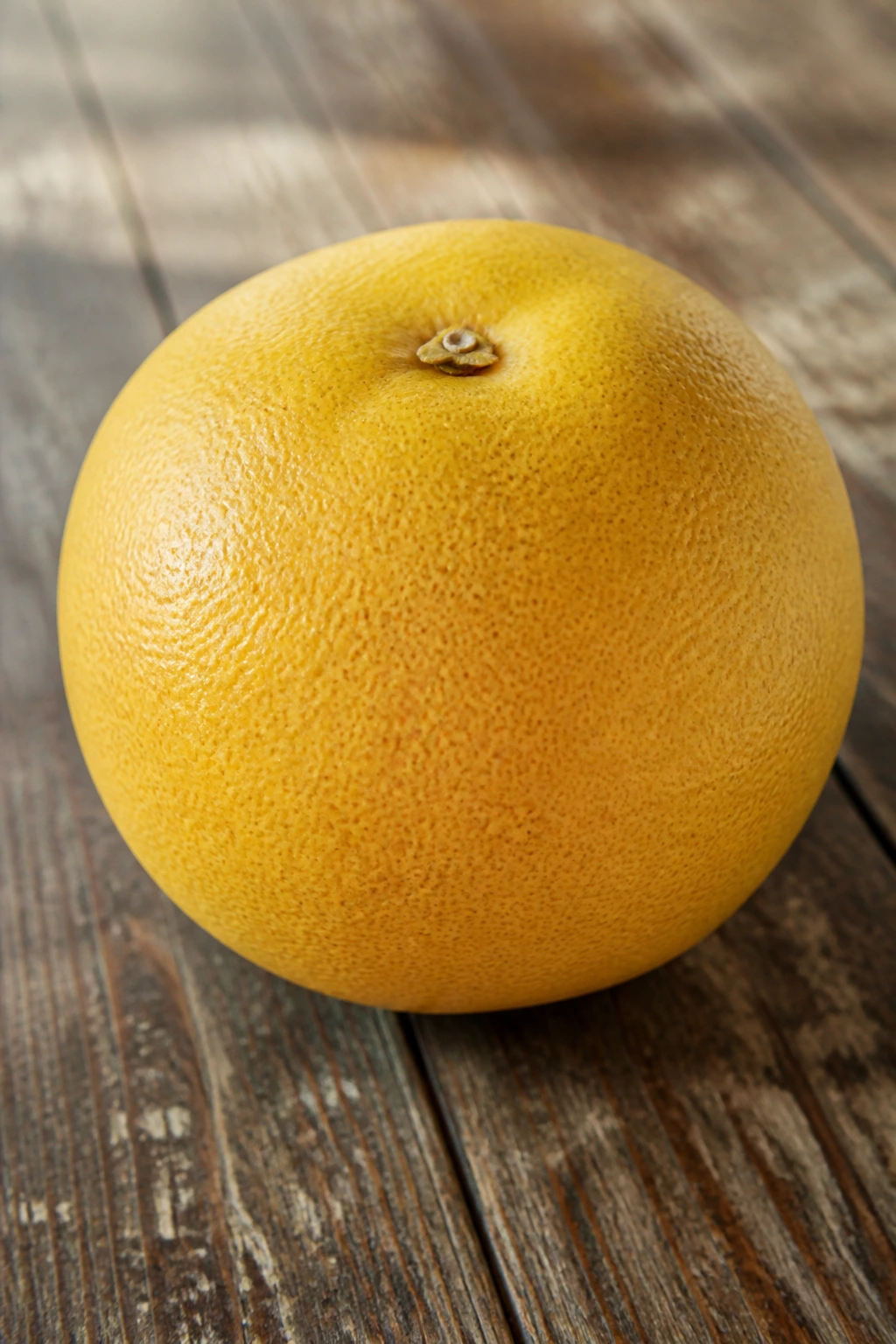 Whole grapefruit on a wooden surface in natural light