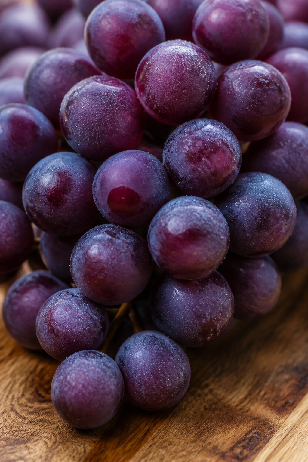 Close-up grapes cluster filling frame on wooden board