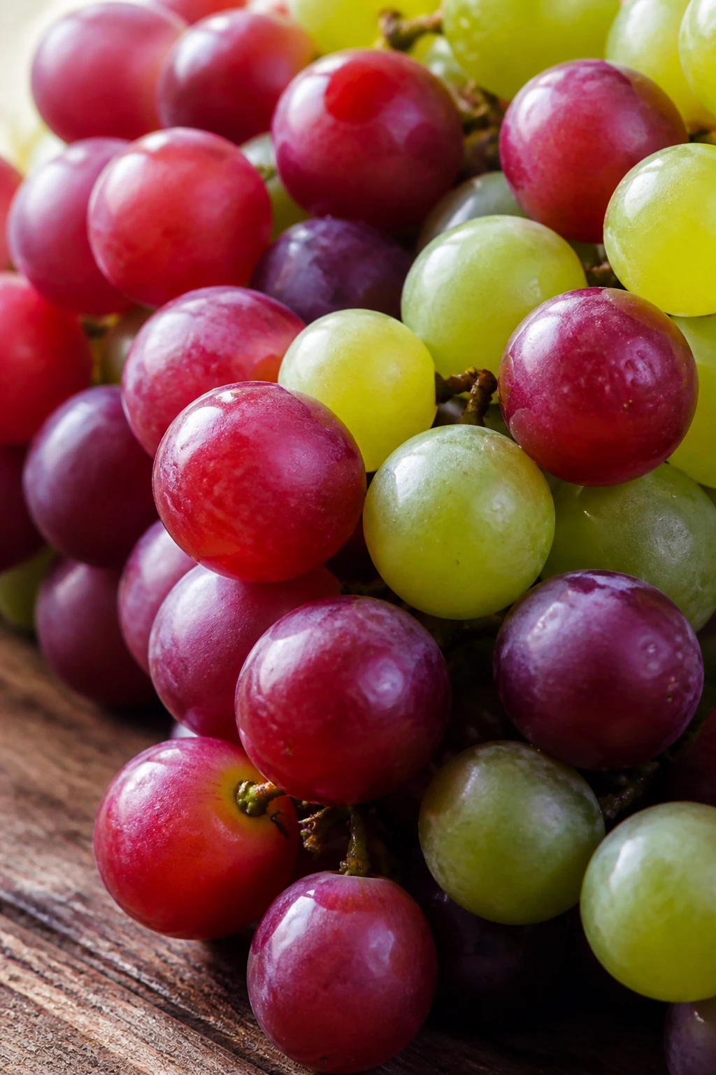 Can Gerbils Eat Grapes? All You Need To Know 3 Close-up grape cluster on wooden surface in warm light