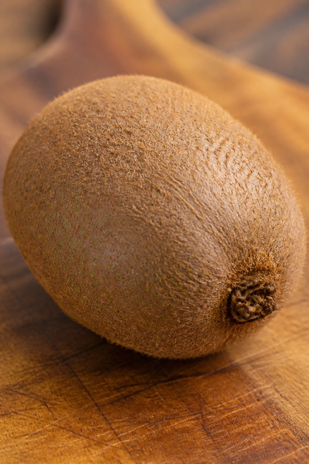 Close-up of a ripe kiwi with fuzzy skin in a kitchen setting