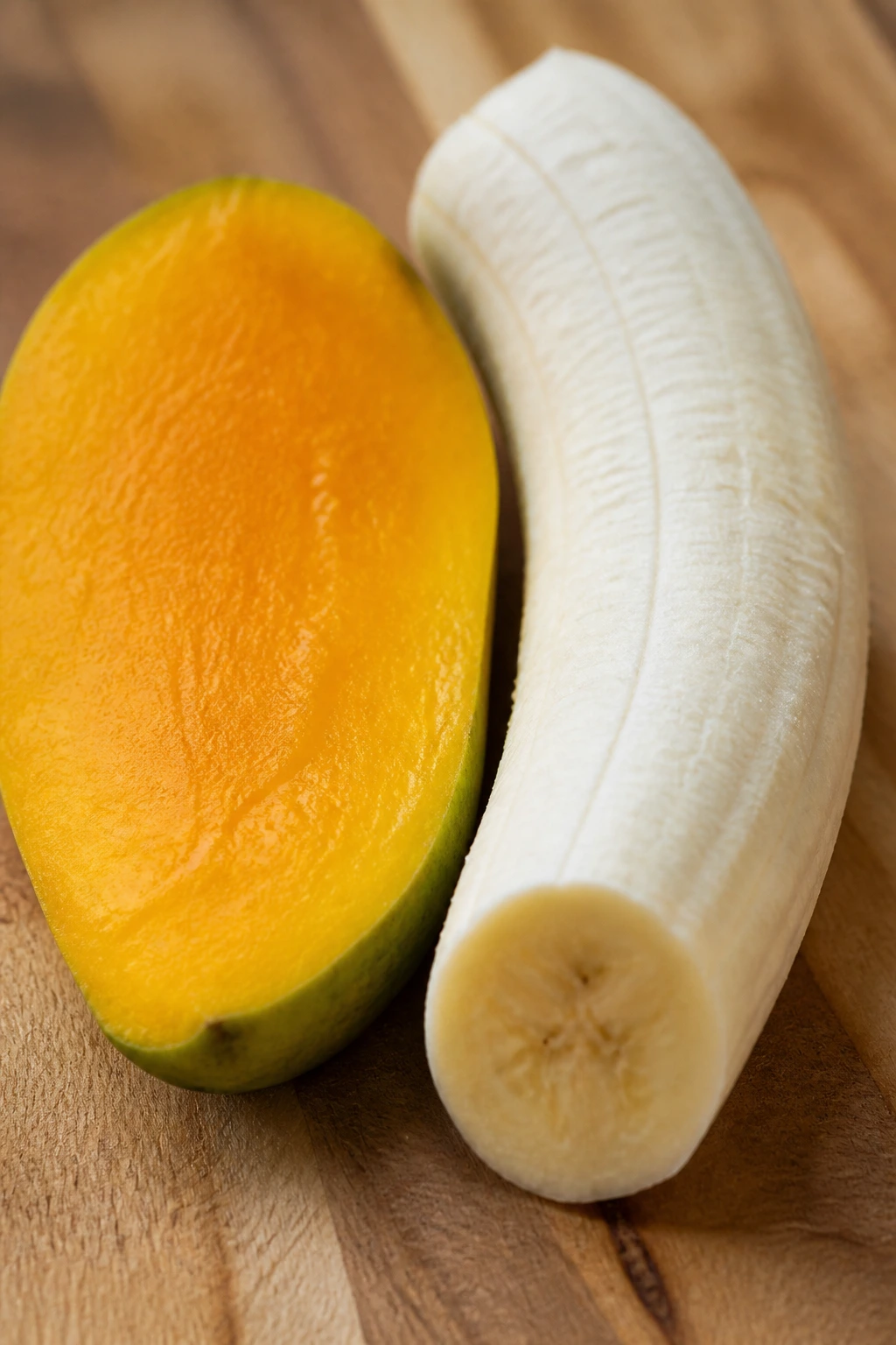 Tropical Showdown: Mango Vs Banana - A Comparison 6 Mango half and banana half side by side on wooden board