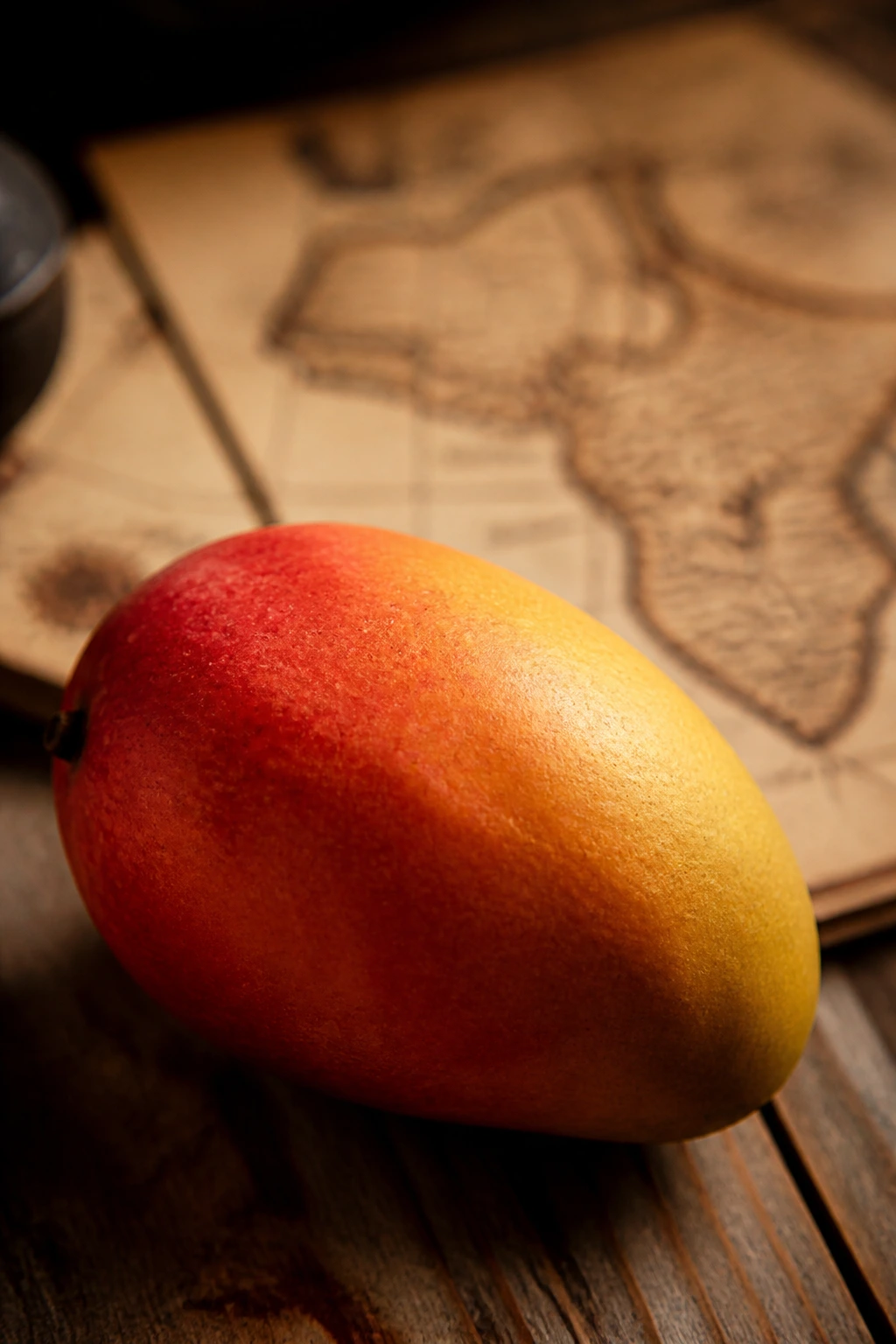 Mango on wooden surface with antique map backdrop