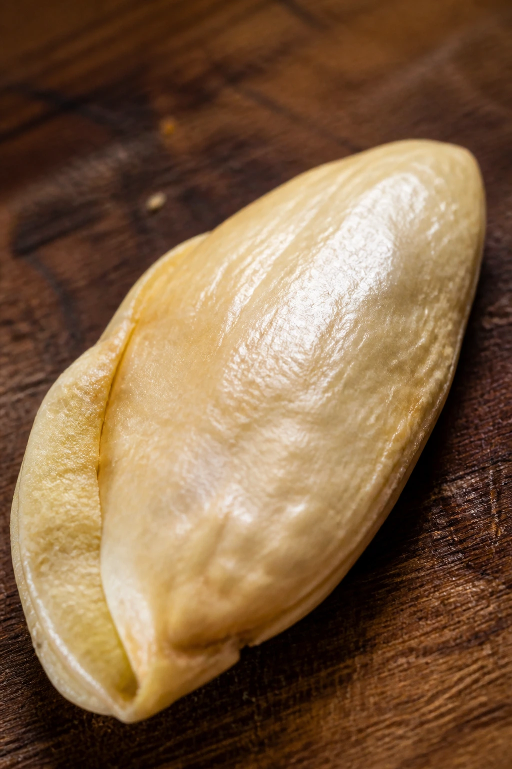 Can You Eat Mango Seeds? What Are The Benefits? 5 Close-up of a mango seed on a wooden board with warm light