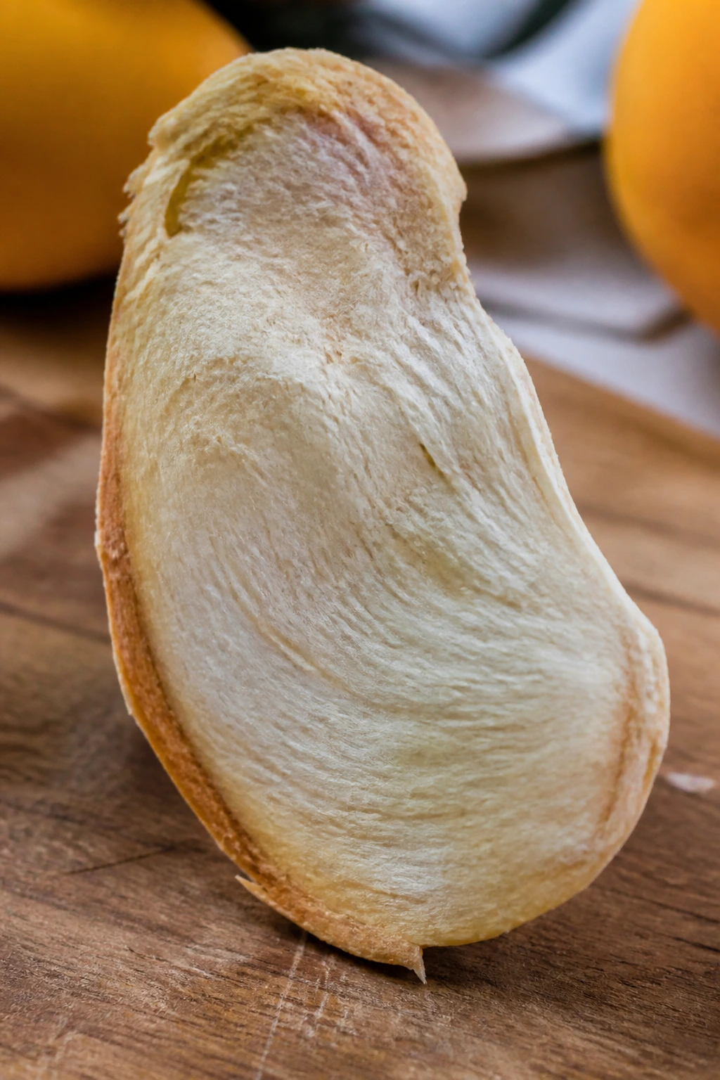 Can You Eat Mango Seeds? What Are The Benefits? 3 Mango seed close-up showing inner texture on a wooden surface