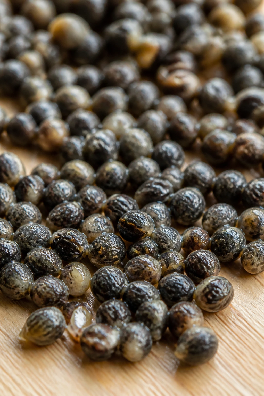 The 10 Surprising Health Benefits Of Pawpaw Seeds 4 Close-up of papaya seeds densely arranged on a wooden surface