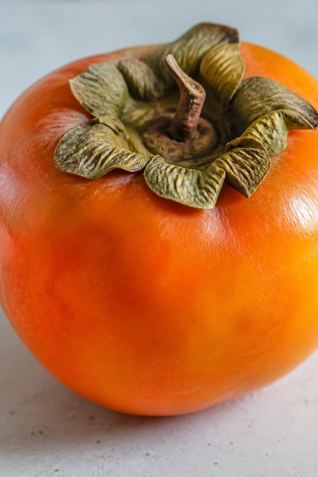 What Is Non Astringent Persimmon? All You Need To Know 3 Single persimmon on light countertop highlighting texture