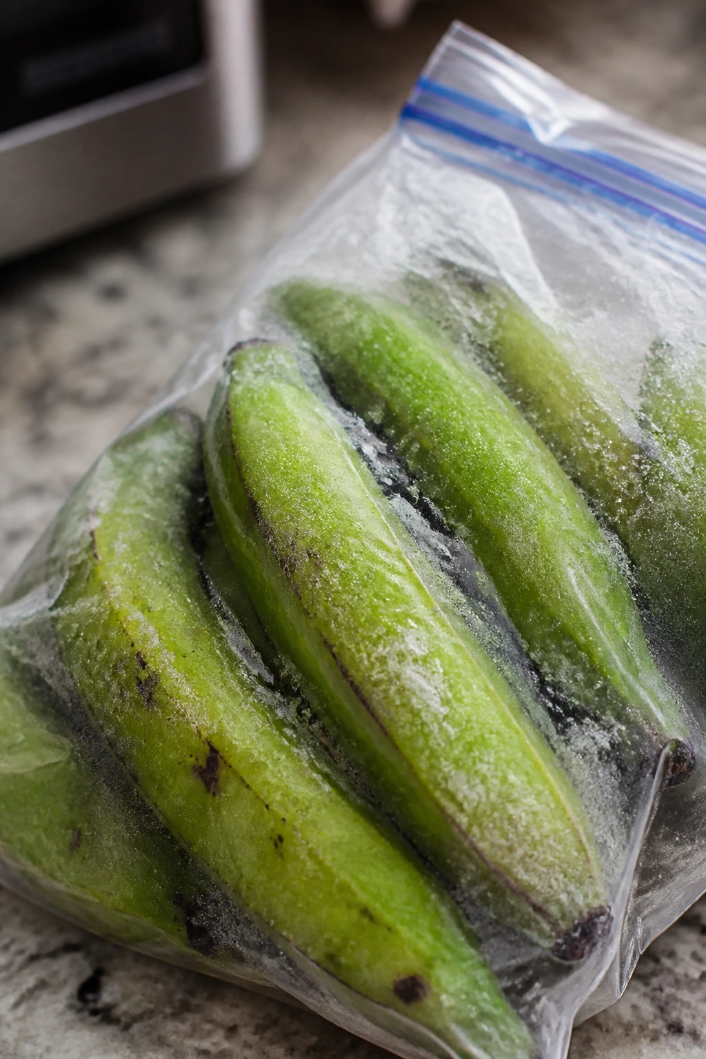Can You Freeze Plantains? All You Need To Know 6 Green plantains in a freezer bag on a kitchen counter.