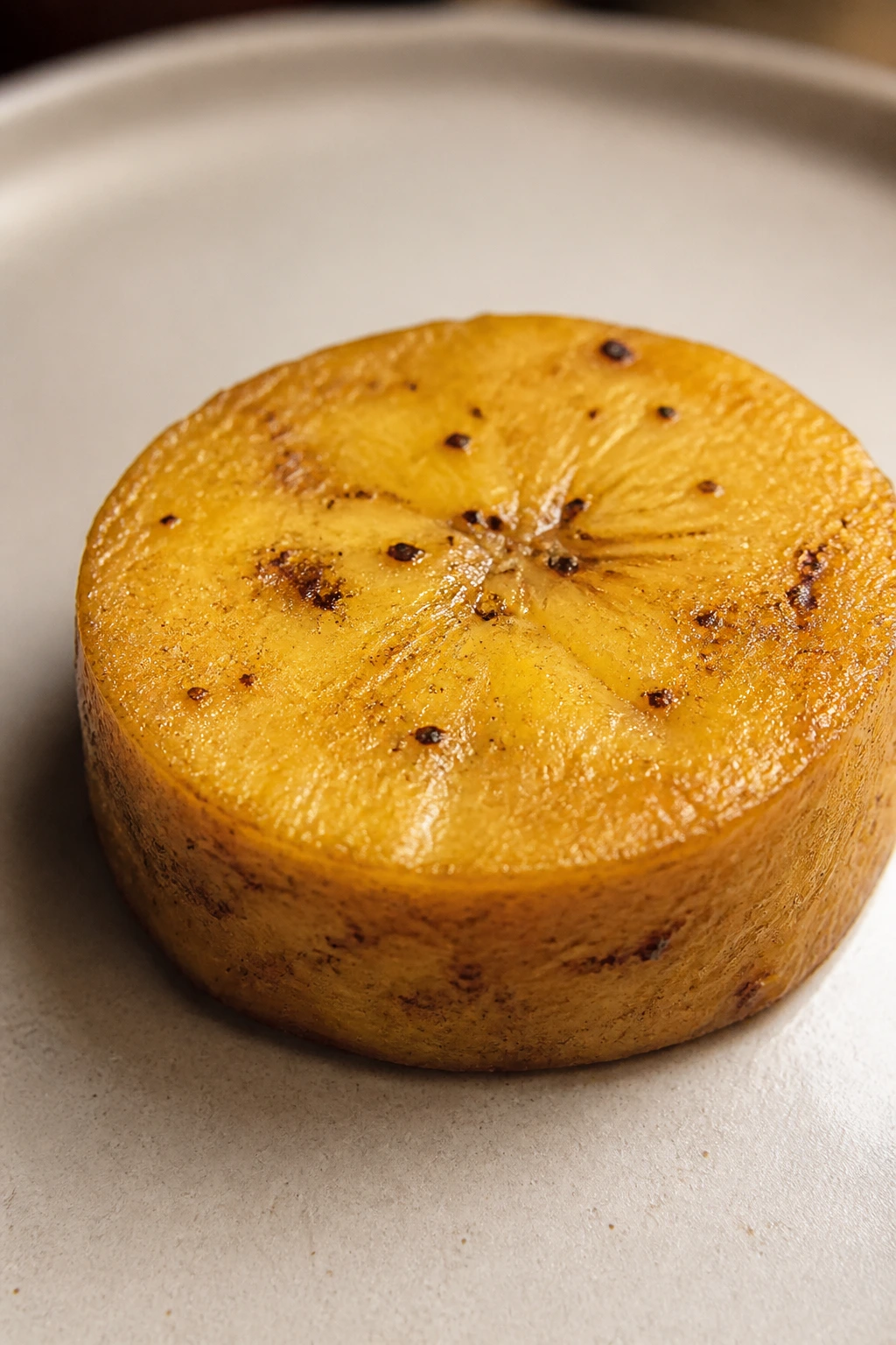 Can Guinea Pigs Eat Plantains? What You Need To Know 3 Plantain slice with brown speckles on a plate in a warm kitchen.
