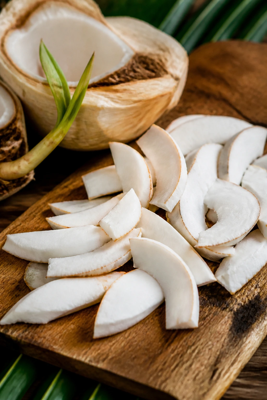 What Is A Sprouted Coconut? Everything You Need To Know 5 Pieces of sprouted coconut meat arranged on a rustic board